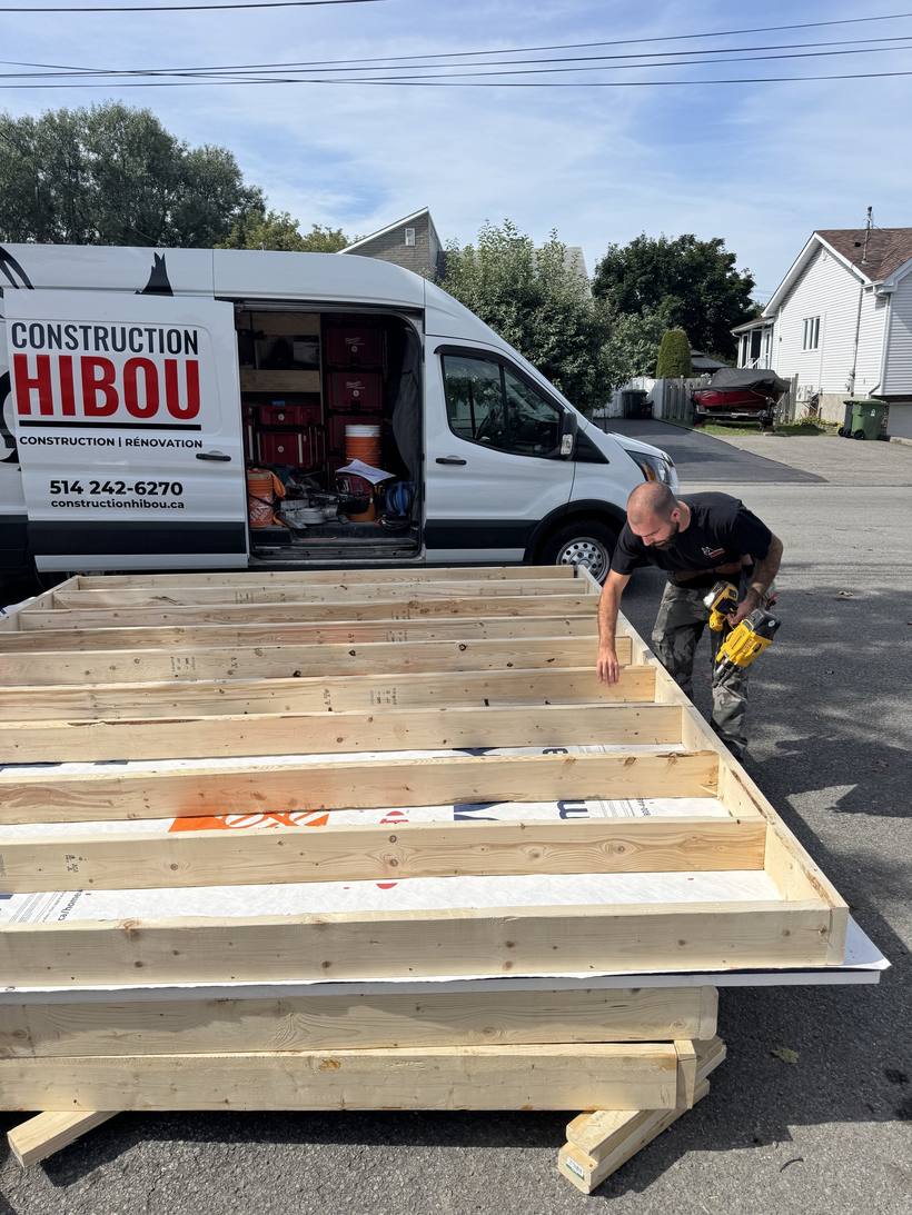 Murs d'ossature assemblés devant le camion identifié de Construction Hibou