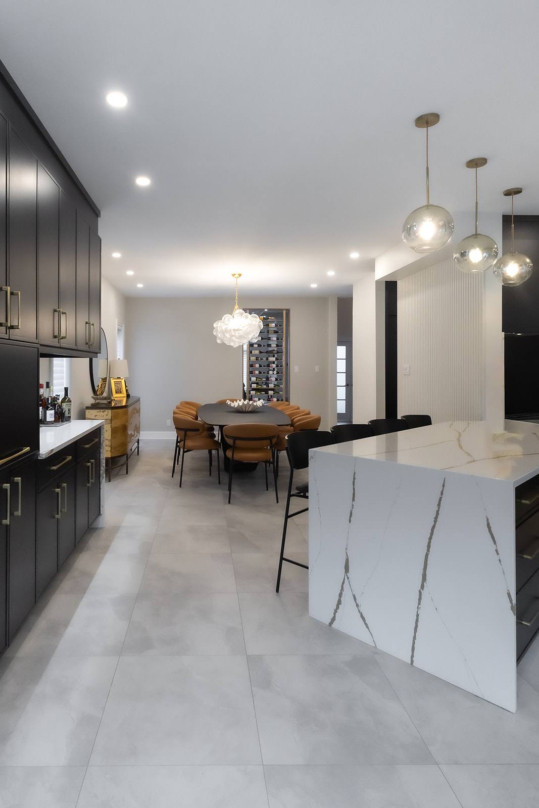Cuisine aux armoires noires avec îlot en quartz à bord cascade