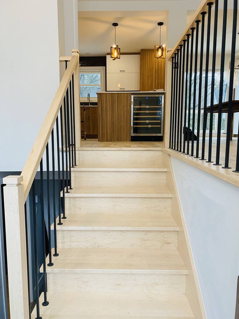 Escalier en bois avec rampe à barreaux noirs