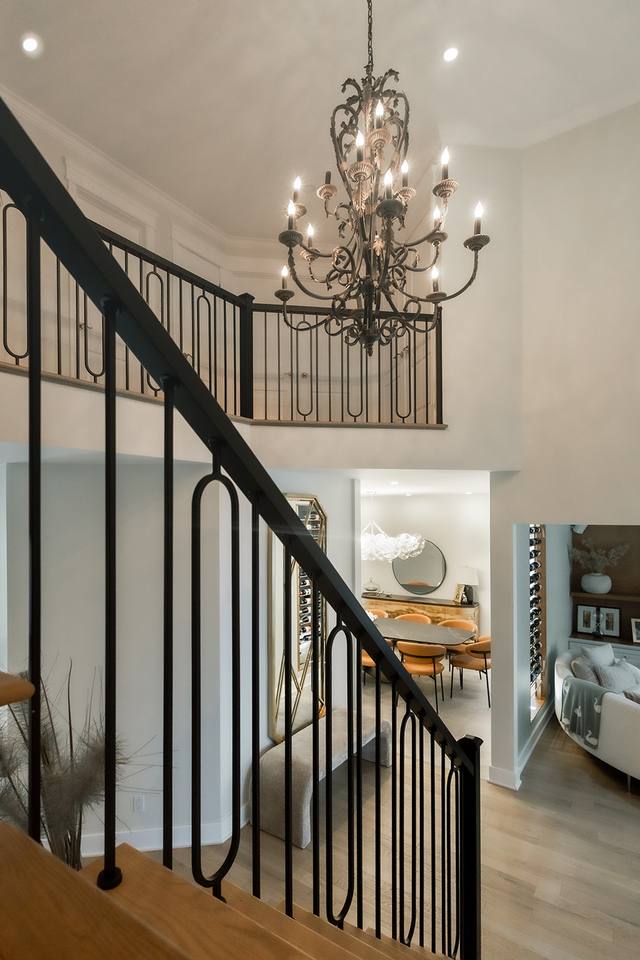 Escalier avec rampe en fer forgé et lustre