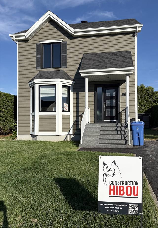 Façade d'une maison terminée avec l'affiche de Construction Hibou