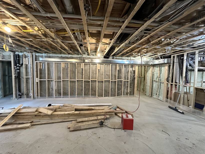 Chantier de rénovation intérieure avec ossature, solives apparentes et bois de construction au sol