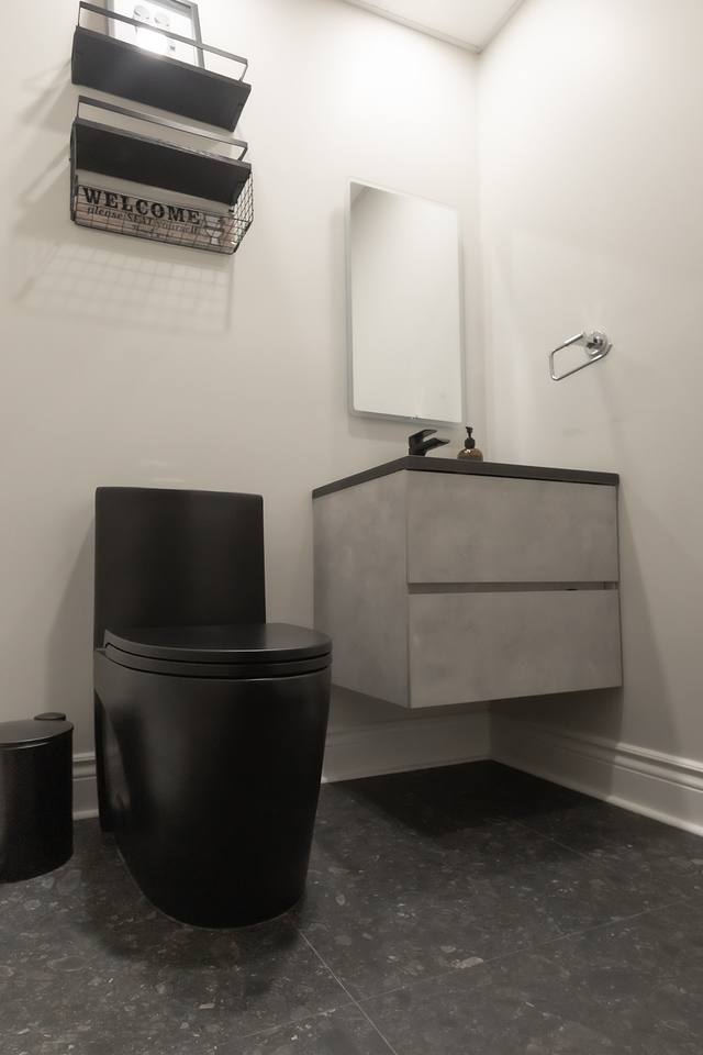 Salle d'eau avec toilette noire et vanité flottante