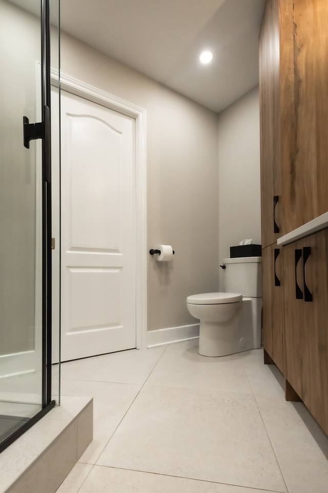 Salle de bain avec armoire en bois et douche vitrée