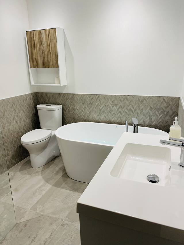 Baignoire autoportante, toilette et vanité dans une salle de bain lumineuse