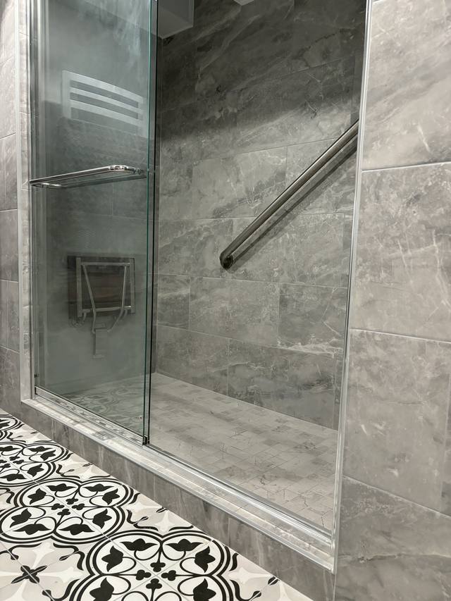 Douche vitrée et plancher de céramique à motifs noir et blanc