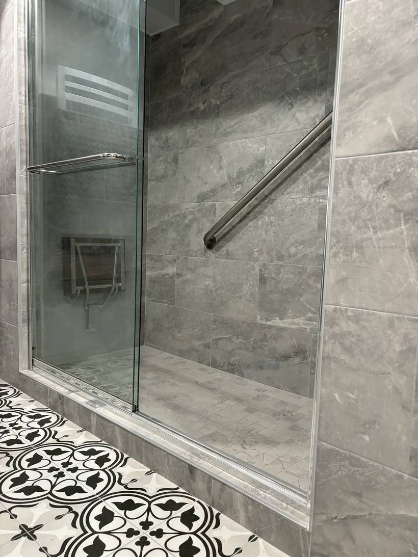 Douche vitrée et plancher de céramique à motifs noir et blanc