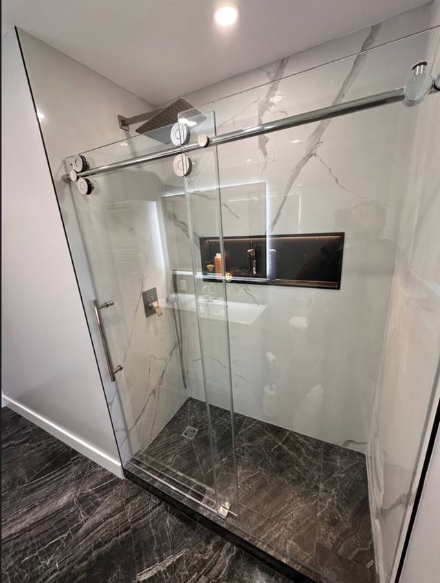 Douche vitrée à porte coulissante et céramique effet marbre