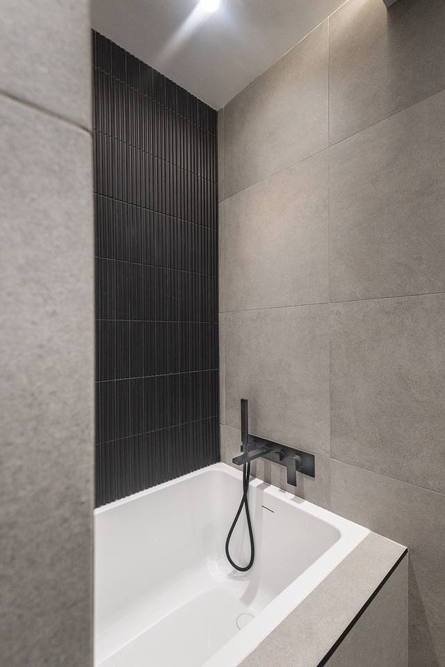 Baignoire et mur de tuile cannelée noire