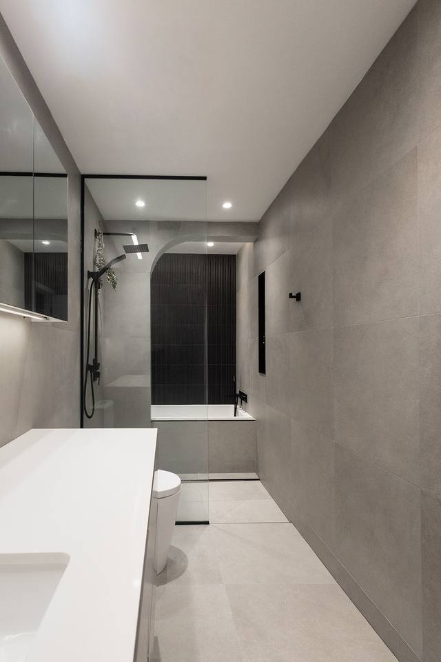 Perspective d'une salle de bain grise jusqu'à la douche