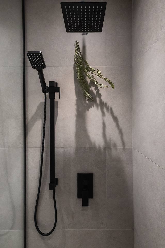 Robinetterie de douche noire sur céramique grise