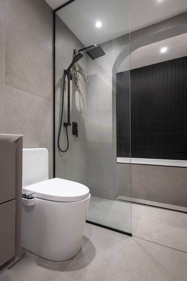 Toilette et douche vitrée dans une salle de bain grise