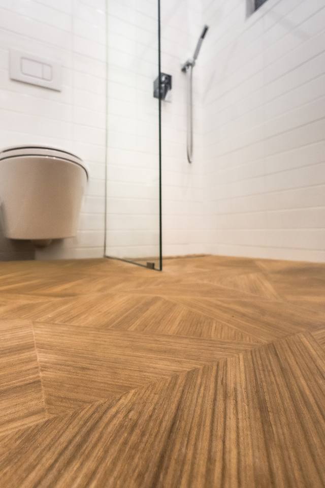 Plancher en chevron et paroi de douche vitrée