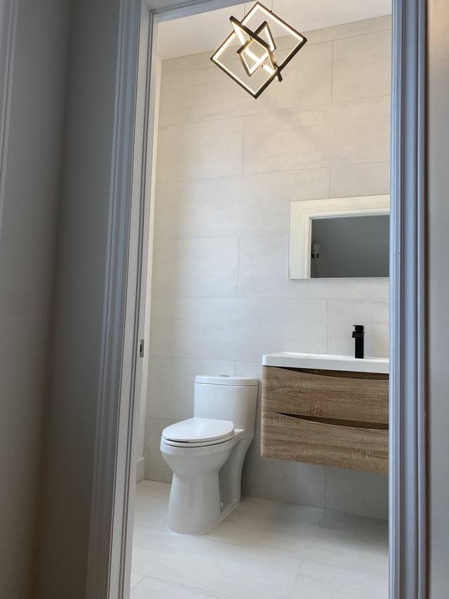Salle d'eau avec vanité flottante et luminaire géométrique