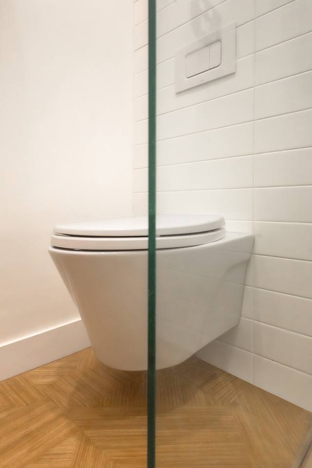 Toilette suspendue et céramique blanche avec plancher en chevron
