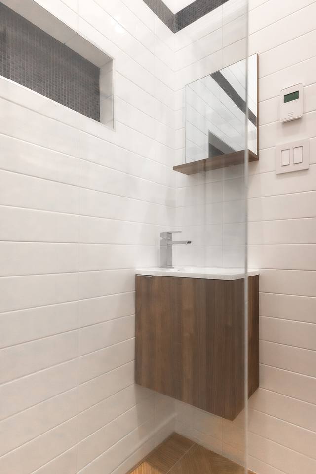 Vanité de noyer et miroir dans une salle de bain en céramique blanche