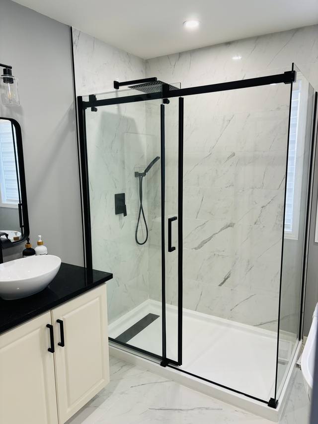 Vasque sur comptoir noir et douche vitrée à cadre noir